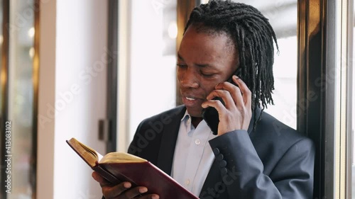 Side view of a smliling businessman talking on a phone being at cafe. Coffee break time. photo