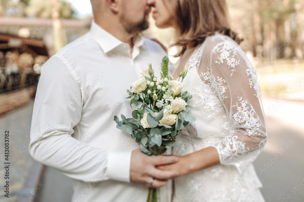 a bride in a beautiful dress with a train holding a bouquet of flowers and greenery a bride in a beautiful dress with a train holding a bouquet of flowers and greenery