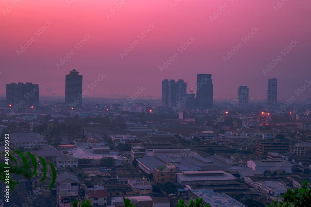 Obraz premium The blurred abstract background of the morning sun exposure to the tiny dust particles that surround the tall buildings in the capital, the long-term health issue of pollution.