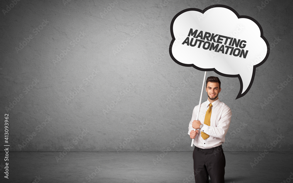 Young business person in casual holding road sign with MARKETING AUTOMATION inscription, new business idea concept Young business person in casual holding road sign with MARKETING AUTOMATION inscription, new business idea concept