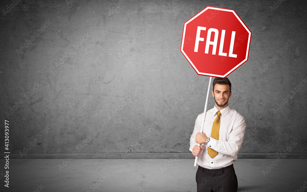 Young business person holding road sign with FALL inscription, new rules concept Young business person holding road sign with FALL inscription, new rules concept
