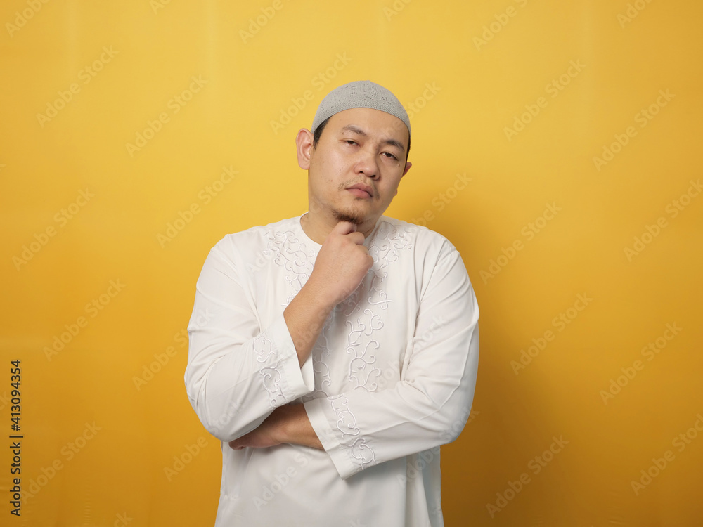 Portrait of cynical Asian muslim man with suspicious expression looking and starring, mistrust misdoubt Portrait of cynical Asian muslim man with suspicious expression looking and starring, mistrust misdoubt