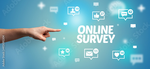 Close-Up of cropped hand pointing at ONLINE SURVEY inscription, social networking concept