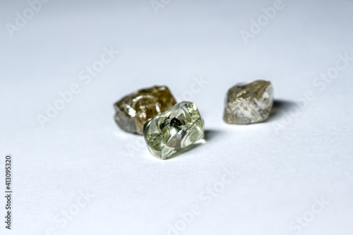 Three multi-colored diamonds lie on a white plastic surface