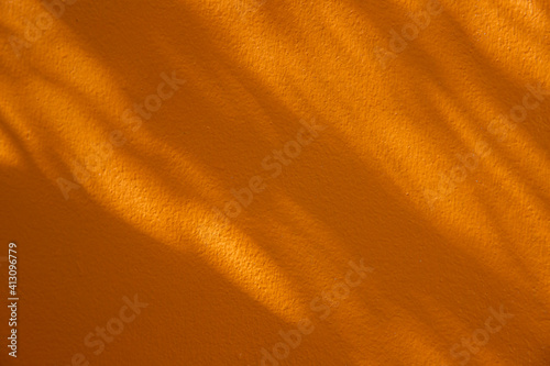 shadow of leaves on yellow concrete wall background