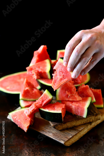 Juicy watermelon slice in hands. Watermelon break.