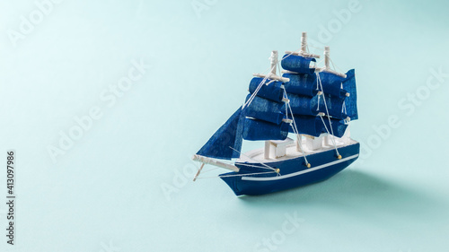 Photography A small toy sailboat on a light blue background.