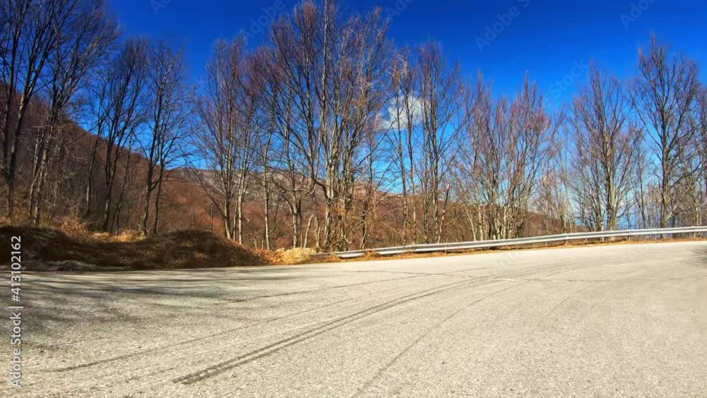 Nature POV drive, colorful countryside winter landscape with bare trees forest, curvy asphalt road and sunny blue sky, car travel gopro point of view Nature POV drive, colorful countryside winter landscape with bare trees forest, curvy asphalt road and sunny blue sky, car travel gopro point of view