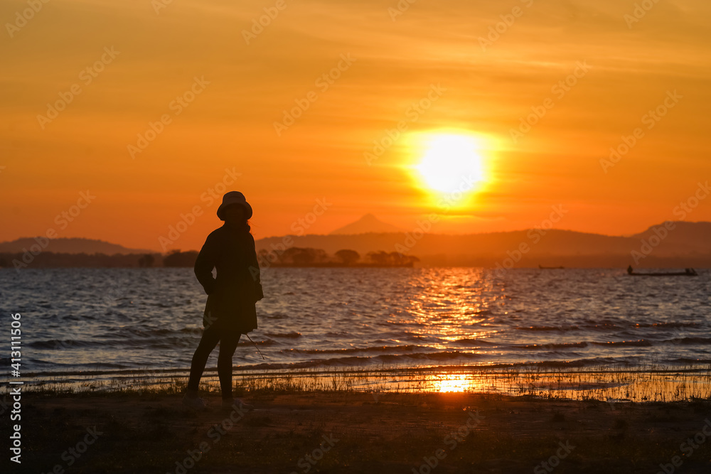 The silhouette of a girl standing in the morning view The silhouette of a girl standing in the morning view