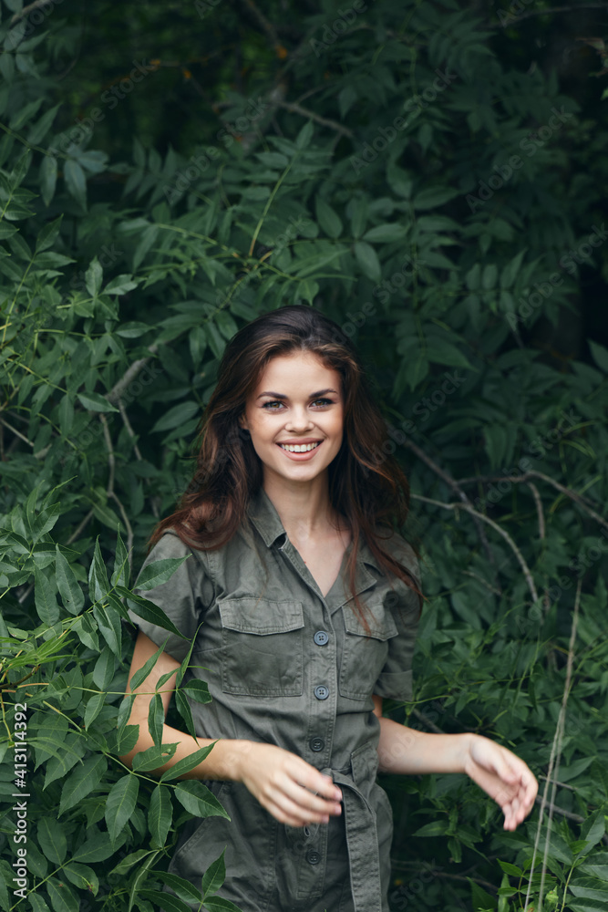 Woman in forest Jumpsuit smile green bushes fresh air Woman in forest Jumpsuit smile green bushes fresh air