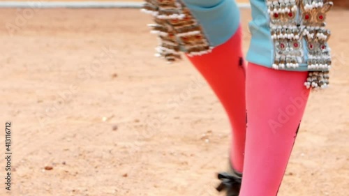 Bullfighter in blue suit of lights slowly walking in the bullring