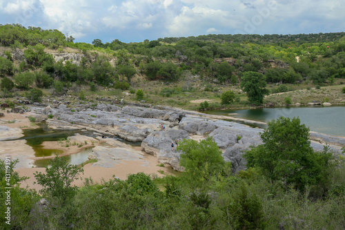 Views of the Pedernales river with a natural stone levee formation creating geological rock poos located at the Pedernales Falls State Park in Texas part of the Central Texas Hill Country
