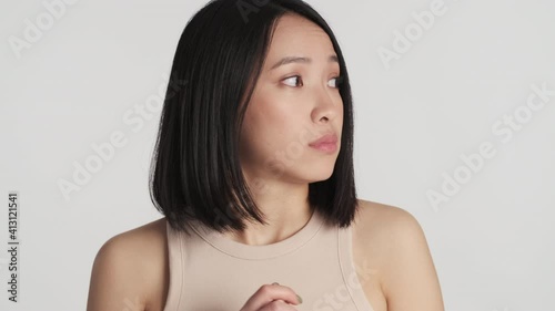 Portrait of nervous Asian girl looking around feeling nervy isolated on white background. Worried woman