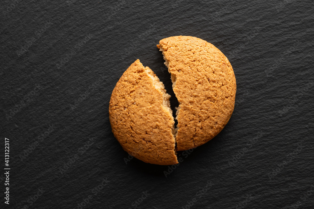 broken in half oatmeal cookies on stone background, top view, place for text broken in half oatmeal cookies on stone background, top view, place for text