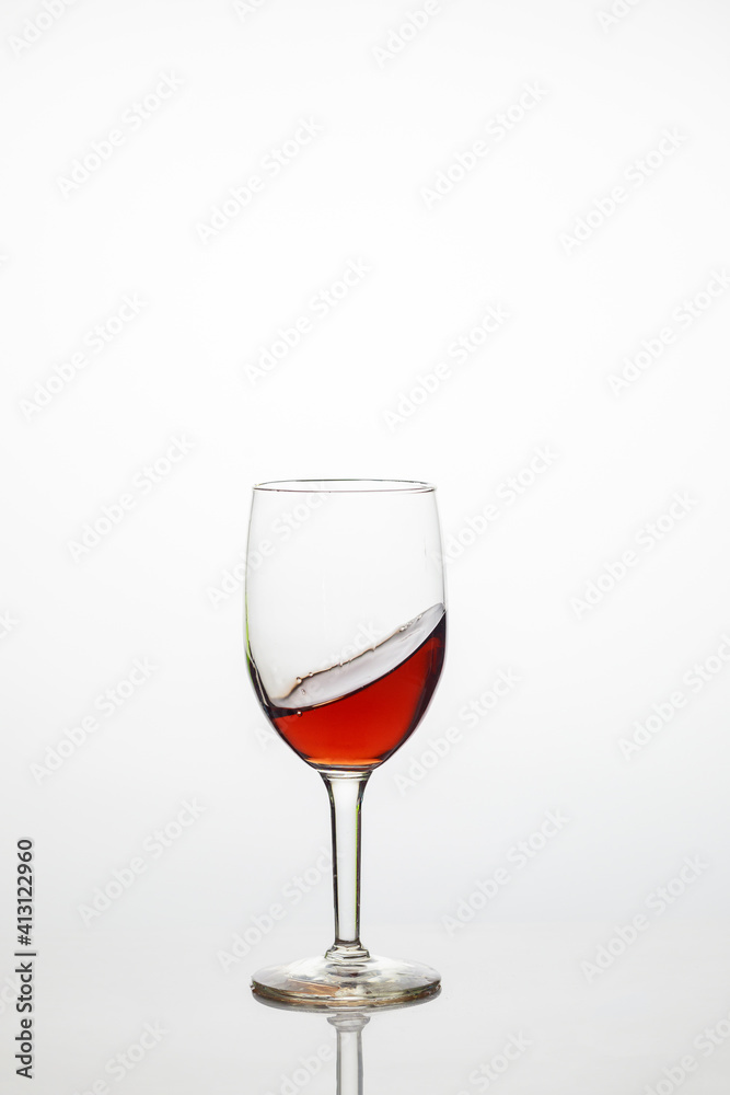 Glass of sweet red wine on white background.