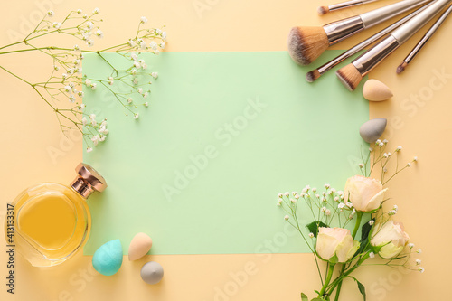 Composition with cosmetics, blank card and spring flowers on color background