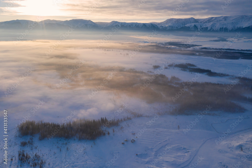 Sunrise above Kuray steppe and North Chuya Mountain Range in winter. Altai Republic, Siberia, Russia..