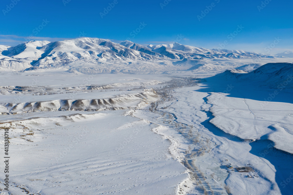 Aerial view of Kyzylchin river valley and Terektinsky Mountain Range in winter. Altai Republic, Siberia, Russia.