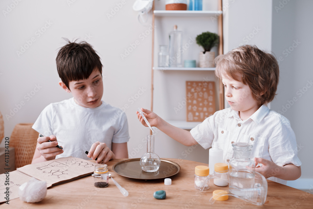 Fototapeta premium Two brothers experimenting in the home laboratory and studying the chemical properties
