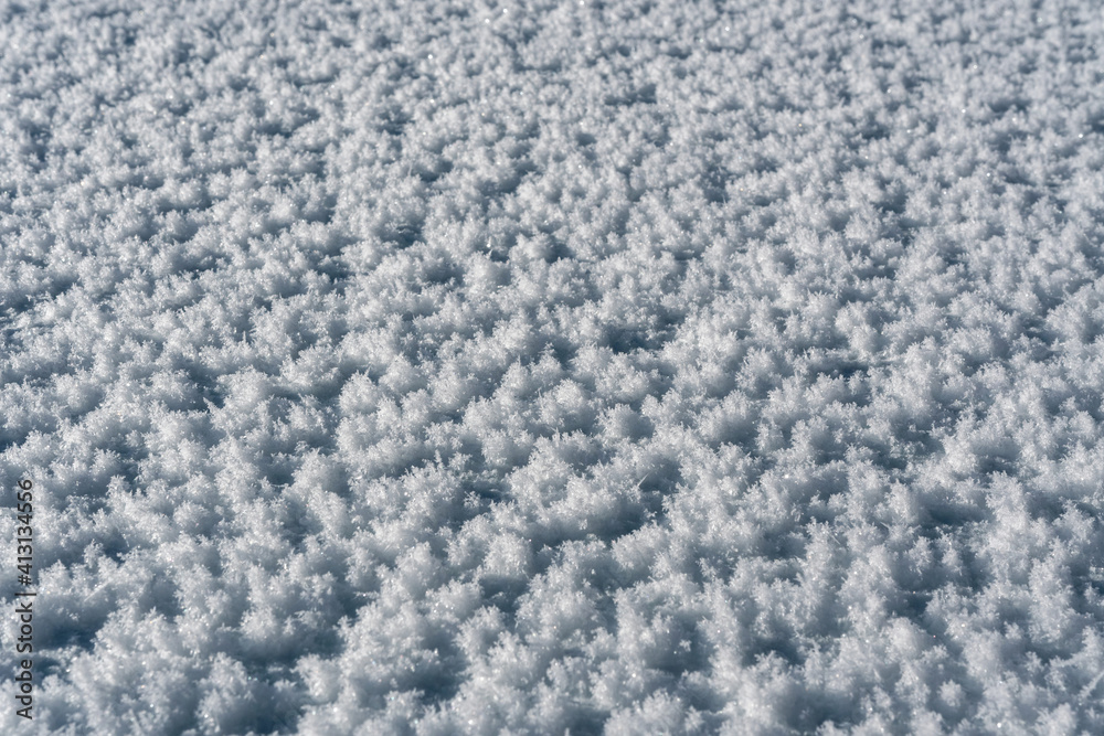 Close up view of the lying snow on a sunny day.