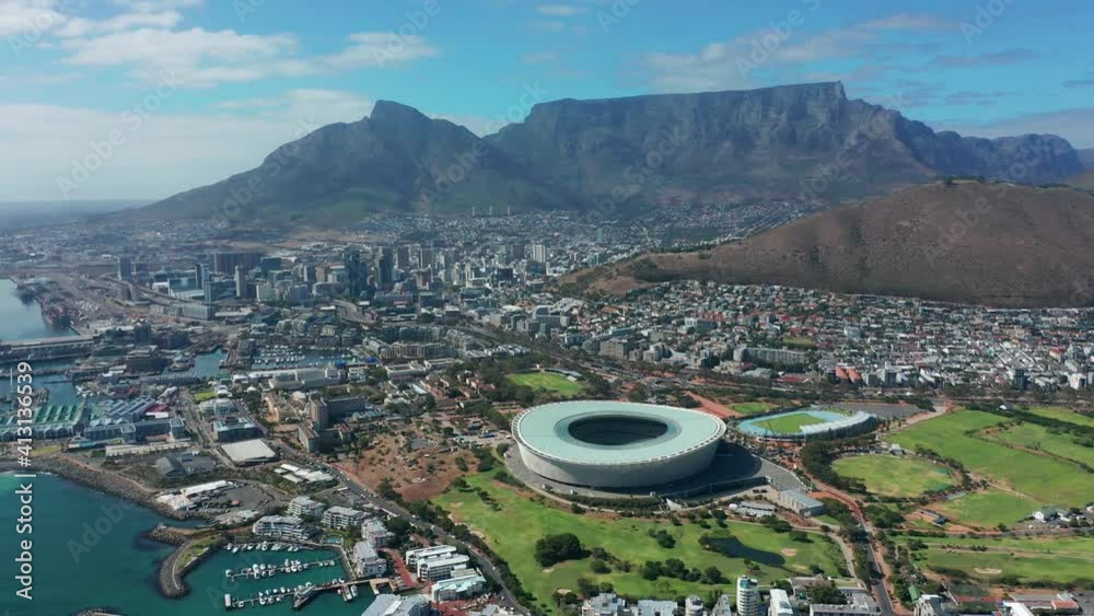 Wide aerial shot tracking forward into the city of Cape Town during a spectacular sunrise with Table Mountain in the background.