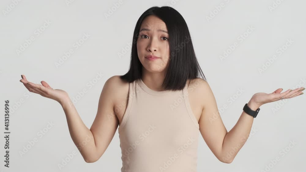 Young Asian woman looking serious throwing up hands on camera isolated on white background. I don't know expression Young Asian woman looking serious throwing up hands on camera isolated on white background. I don't know expression
