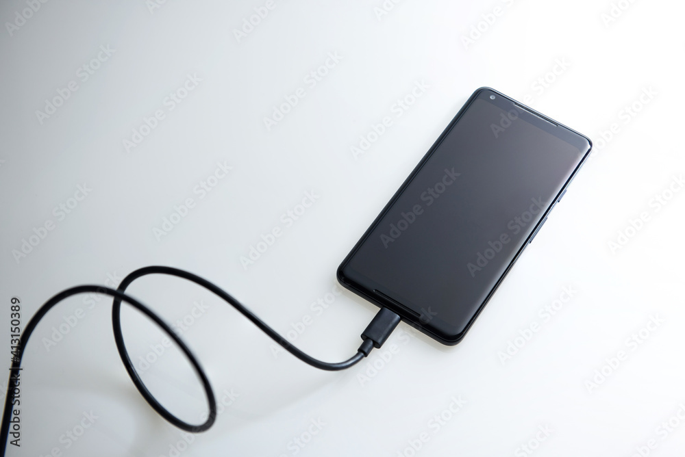 Close-up view of android phone with charging cable from Google Close-up view of android phone with charging cable from Google