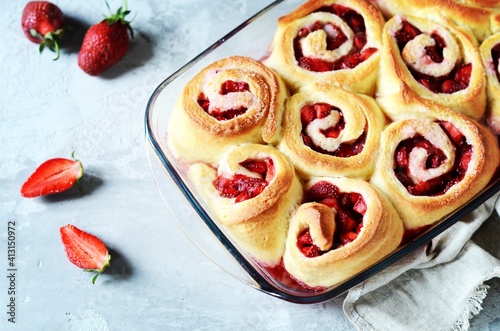 Homemade yeast buns with strawberries on gray background