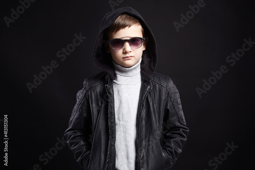 funny little boy in hoodie and sunglasses