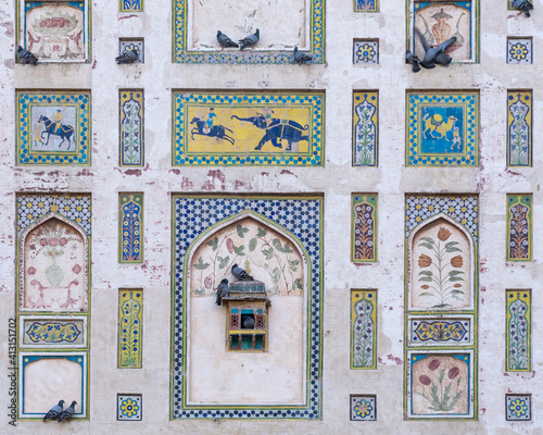 Detail of colorful Picture Wall built by mughal emperor Jahangir in Lahore fort, Punjab, Pakistan with beautiful painting and mosaic and resting pigeons photo