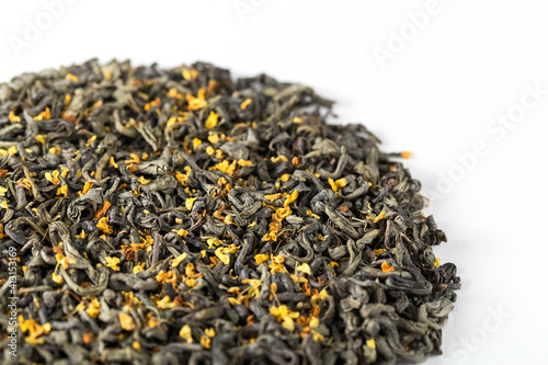 Texture of dry green tea with osmanthus flowers on a white background. China oolong tea macro photography