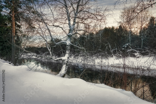 Winter landscape the river in the forest at sunset. Winter sunset rural river landscape.