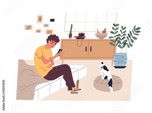 Teen boy surfing internet, listening to music and taking photo of cat at home...