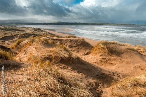 Sand dunes by the ocean. Blue cloudy sky. Nature background. Strandhill beach  Sligo  Ireland. Warm and sunny day