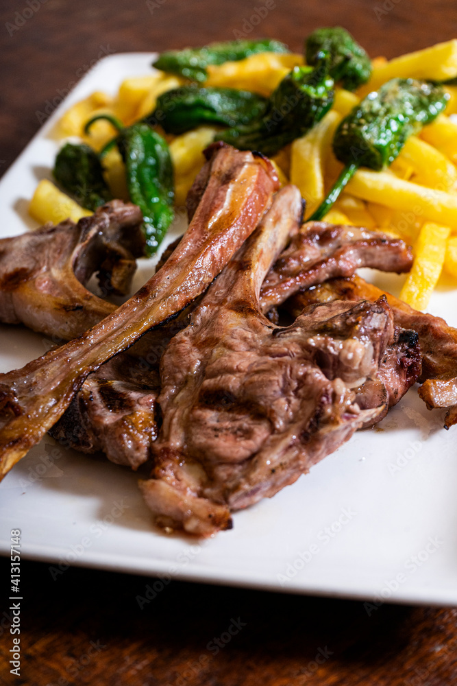 Grilled lamb ribs. Meat served with French fries and peppers. Vertical picture