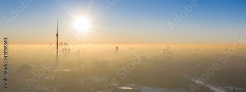 Contre-jour panoramic aerial view of the city and Ostankino tower at sunny winter day. Moscow, Russia.