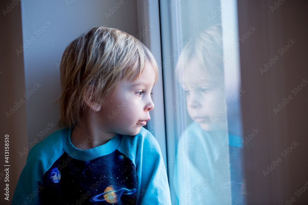 toddler child, sitting on the window on sunset toddler child, sitting on the window on sunset