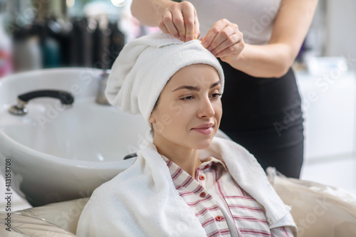 Hair stylist drying her clients hair with a towel