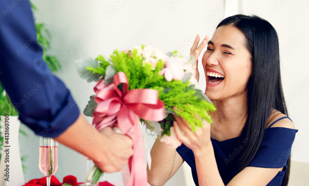 A cute young and beautiful long hair Asian woman feels shy when the man gives her rose bouquet A cute young and beautiful long hair Asian woman feels shy when the man gives her rose bouquet