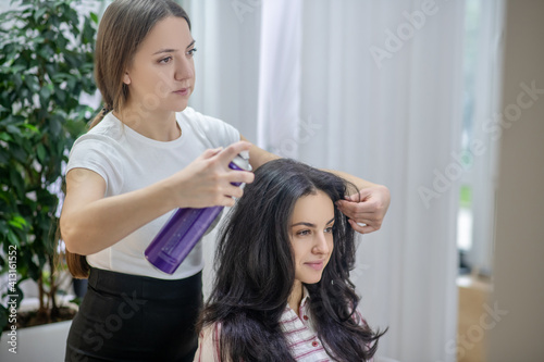 Young long-haired woman making hairstyling in a hair salon