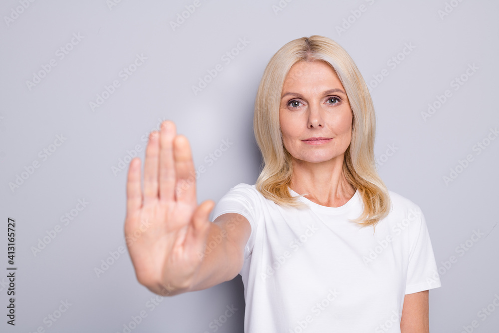 Fototapeta premium Portrait of blond sad old lady show no wear white cloth isolated on grey color background