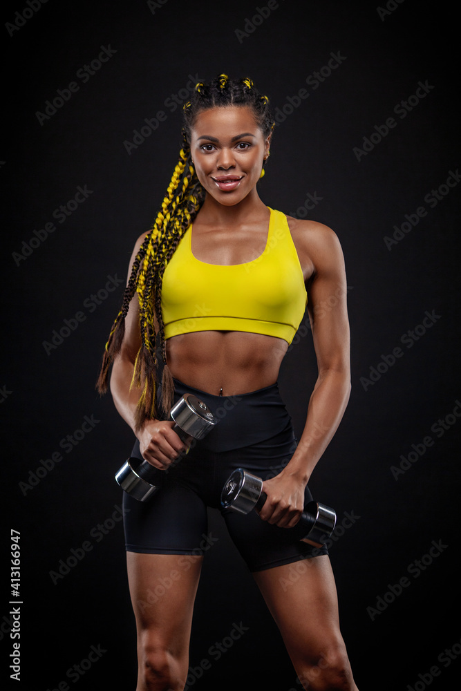 African american woman athlete bodybuilder. Muscular young fitness sports woman workout with dumbbells in fitness gym.