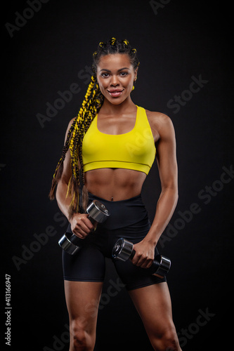 African american woman athlete bodybuilder. Muscular young fitness sports woman workout with dumbbells in fitness gym.