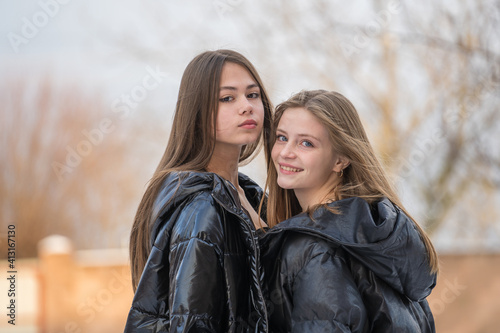 Portrait of two charming young girls, outdoors, close up