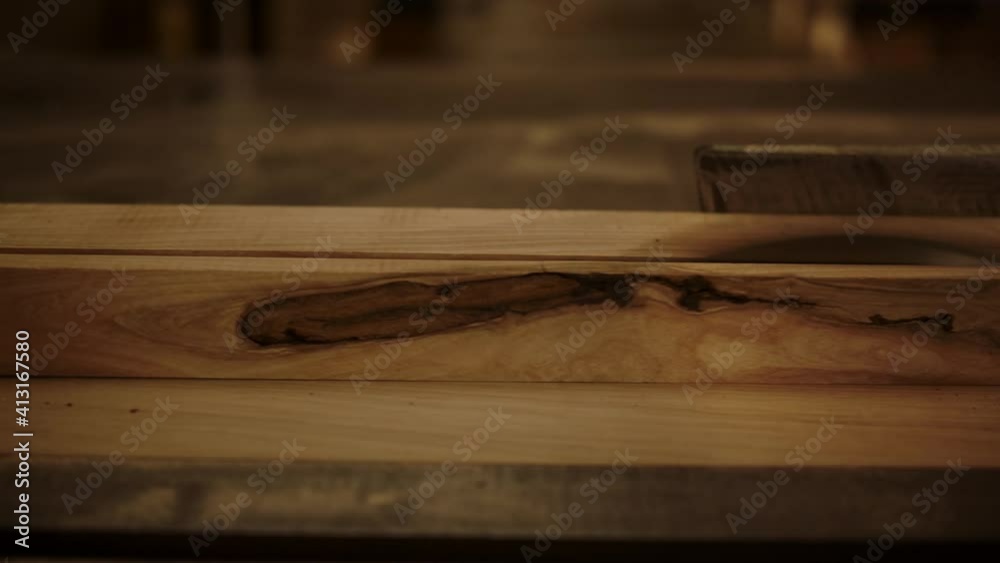 Unknown guy cutting plank indoors. Guy working with saw machine in studio Unknown guy cutting plank indoors. Guy working with saw machine in studio