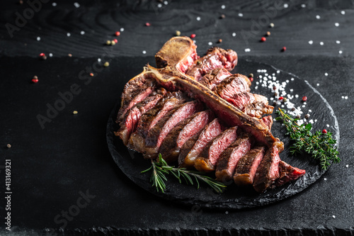 Foto Beef T-Bone steak or aged wagyu porterhouse grilled beef steak Medium rare on a black table