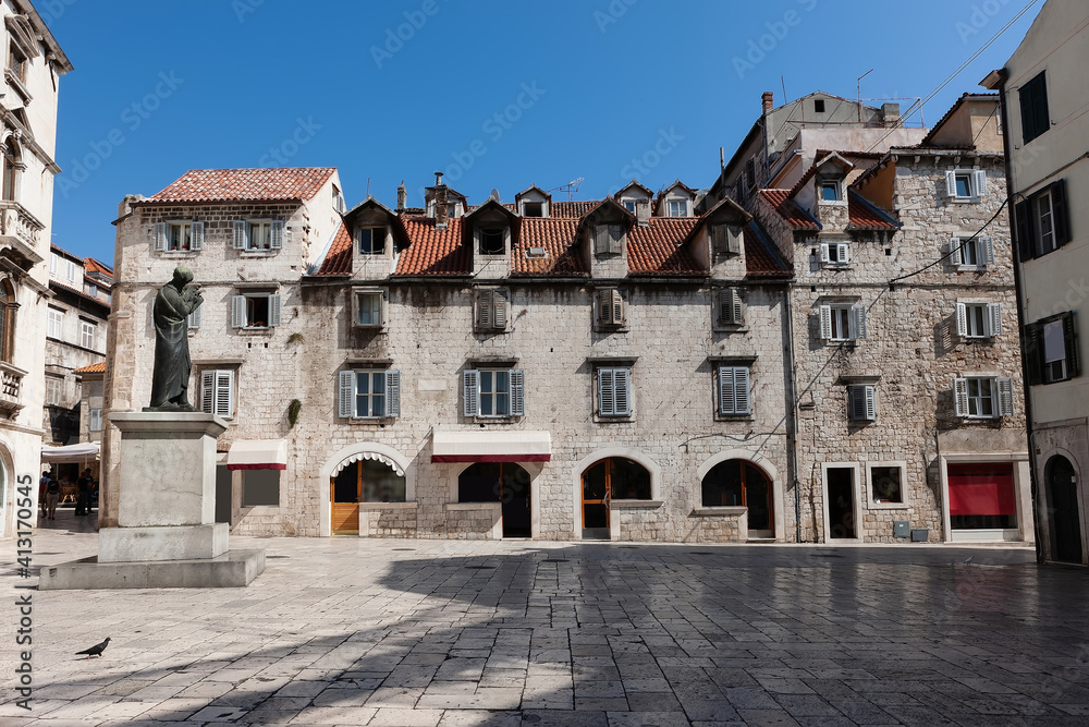 Old streets, architecture. Old facades and red tiled roofs. Scene from the old city of Split and the view of old bell tower