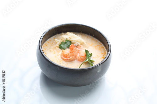 Tom yum with shrimps, isolated on white. A close-up of a spicy and sour soup with coconut milk.