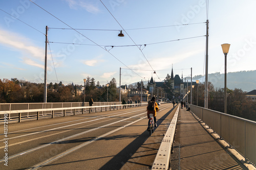 Woman cycling on the bridge and the Einstein museum in the background in Bern