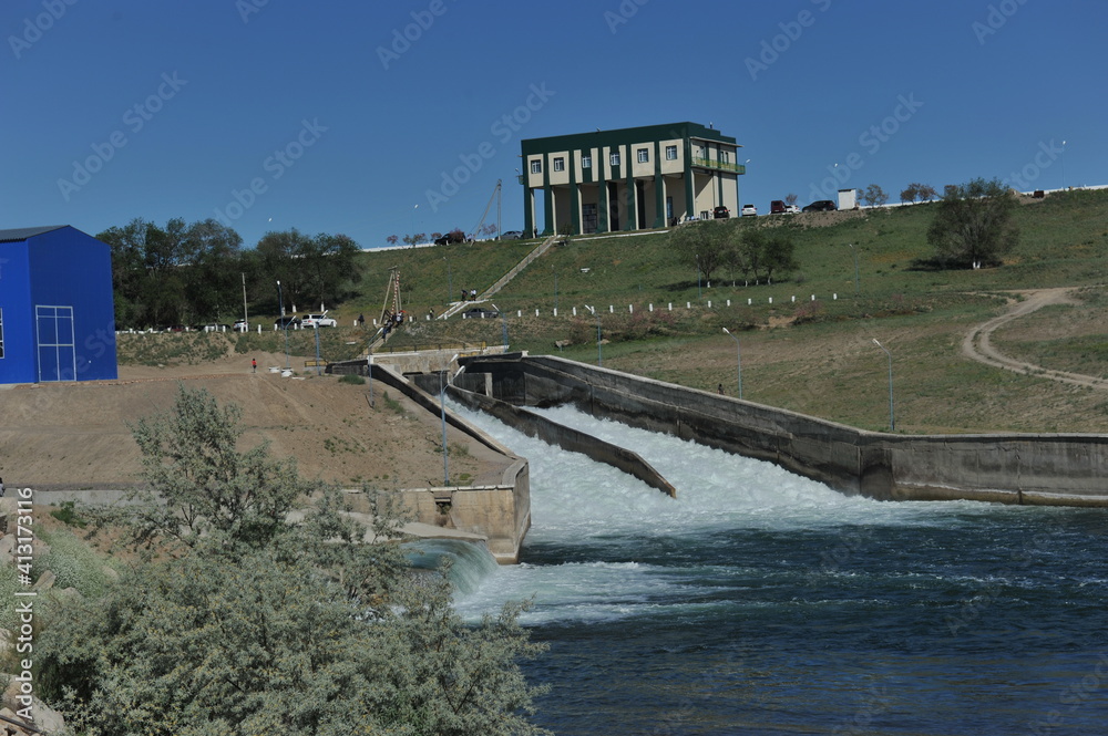 Fototapeta premium Zhambyl region, Kazakhstan - 05.15.2013 : Dam water discharge bay on the background of the main building of the hydroelectric power station
